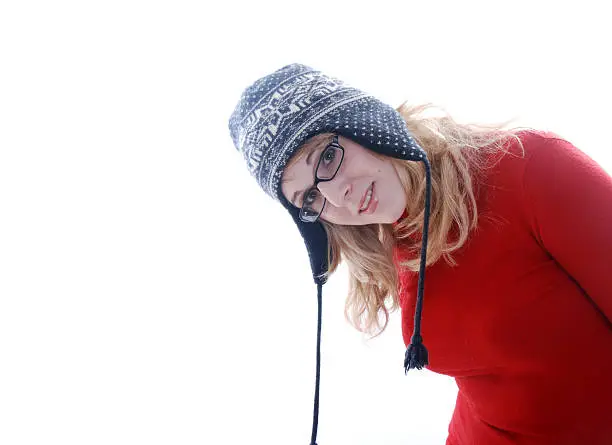 Pretty blonde haired girl leaning into shot wearing a ski bobble hat