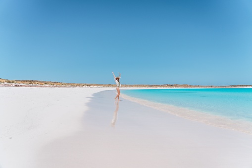 A young happy Caucasian female enjoying her vacation at the sandy beach