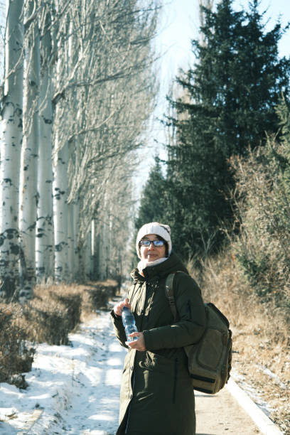 istock Woman is drinking water in winter park 1452464180