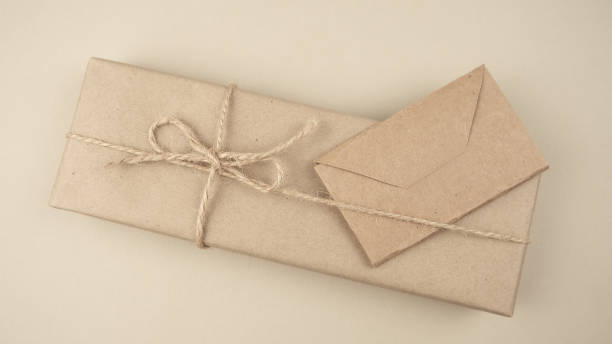 istock Gift box wrapped in kraft paper on a light background. Holiday concept. Valentine's Day. Place for text or advertising. Present. 1452465700