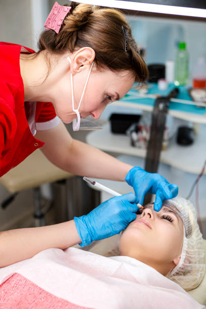 istock Microblading, Micropigmentation  Concepts. Eyebrows Workflow in Beauty Salon for Woman Having Her Eyebrows Drawn and Tinted With Semi-Permanent Makeup Using Translucent Ruler and Pencil 1452465712