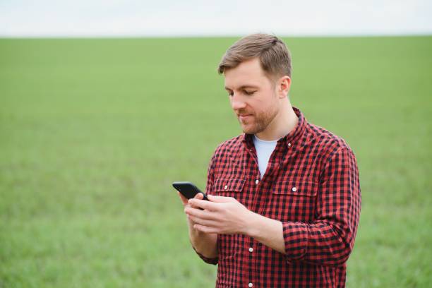 istock Handsome farmer. Young man walking in green field. Spring agriculture. 1452465731