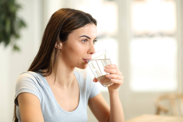 istock Woman drinking water at home 1452467186