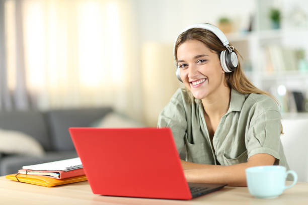 istock Happy student with laptop looks at you 1452467314