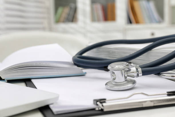 istock Book, stethoscope and clipboard on white table indoors, closeup with space for text. Medical education 1452468779