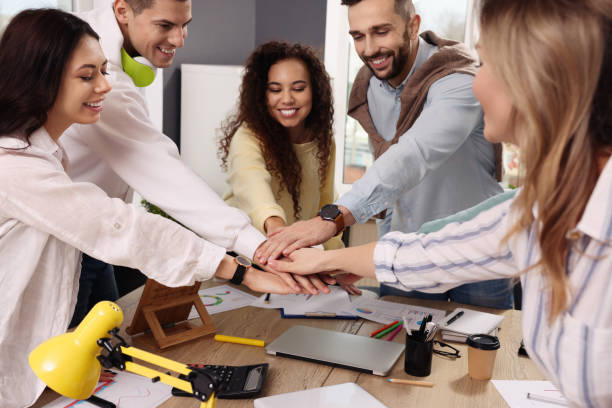 istock Team of employees putting hands together in office. Startup project 1452468780