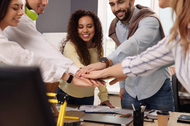 istock Team of employees putting hands together in office. Startup project 1452468781