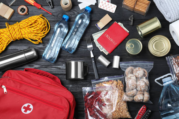 istock Disaster supply kit for earthquake on black wooden table, flat lay 1452469230
