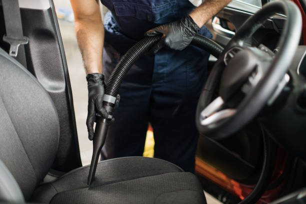 istock Auto car service worker using vacuum cleaner to wash car seat. 1452469958