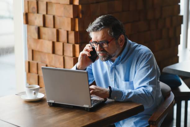 istock Business, technology and people concept , senior businessman with laptop computer drinking coffee at modern cafe. 1452470394