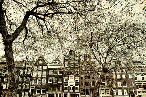 Historic buildings in the city of Amsterdam. Typical Dutch brick houses in Holland. Vintage style toned picture