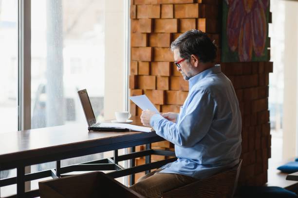istock Business, technology and people concept , senior businessman with laptop computer drinking coffee at modern cafe. 1452470939