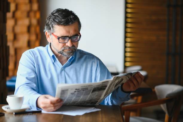 istock coffee break. man drinking coffee and reading newspaper in cafe bar 1452471222