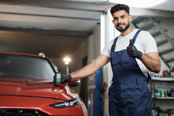 istock Professional service specialist testing thickness of the car paint in protective gloves. 1452471802