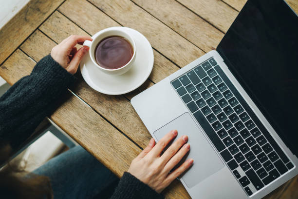 istock Closeup woman hands working on the laptop and drinking coffee 1452473709