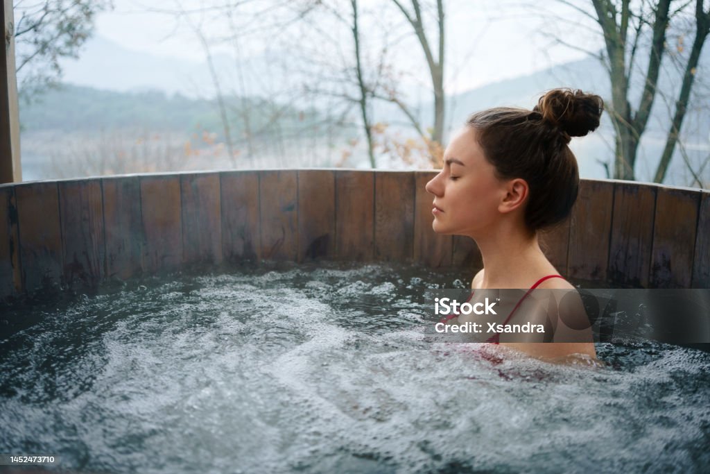 Woman relaxing in the outdoor hot tub Woman relaxing in the outdoor spa Hot Tub Stock Photo
