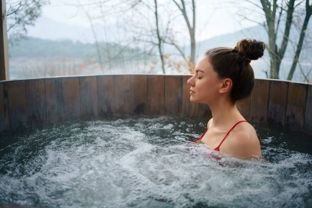 Woman relaxing in the outdoor hot tub stock photo