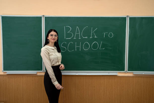 istock young pretty teacher standing near classboard 1452474431