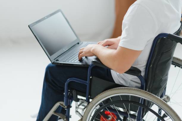 istock Person with a disability working on laptop in living room. 1452476498