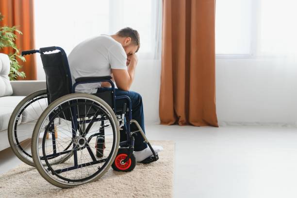 istock Young sad man in a wheelchair at home. 1452477941