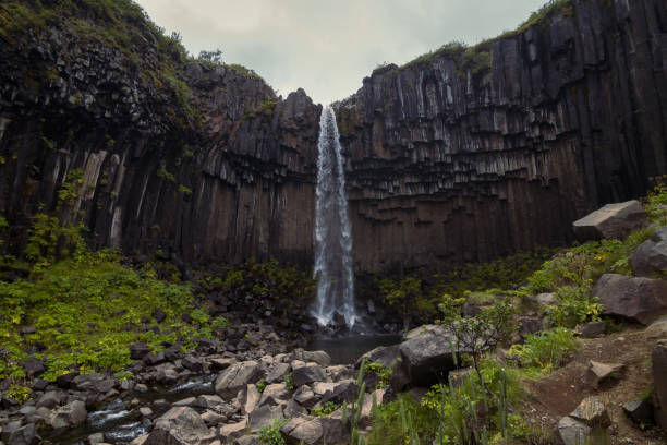 istock Waterfall on textured cliff landscape photo 1452480792