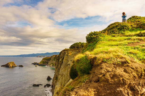 istock Tourist with camera on Asturias coast. Cabo Busto cliffs, Spain. 1452482153