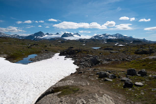 Snow capped mountains and crystal clear lakes along the Sognefjellsvegen, highest mountain road of Northern Europe stock photo