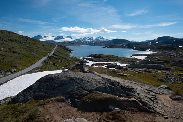 Snow capped mountains and crystal clear lakes along the Sognefjellsvegen, highest mountain road of Northern Europe stock photo