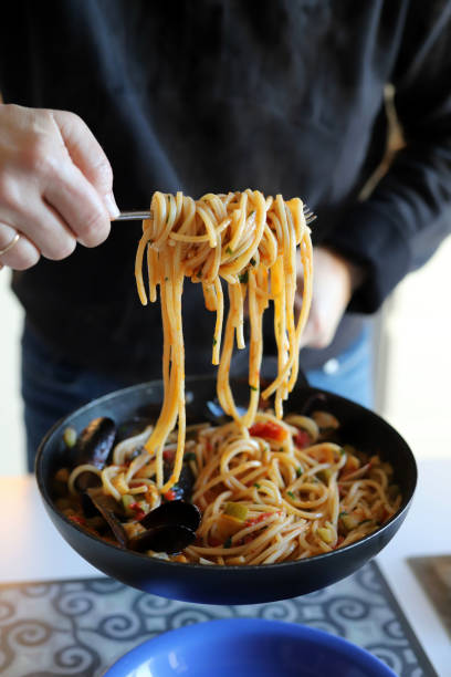 istock Woman serving pasta spaghetti with seafood. 1452482905