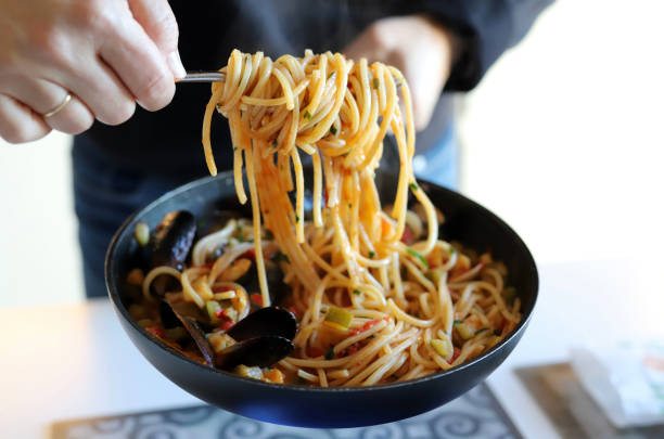 istock Woman serving pasta spaghetti with seafood. 1452482942