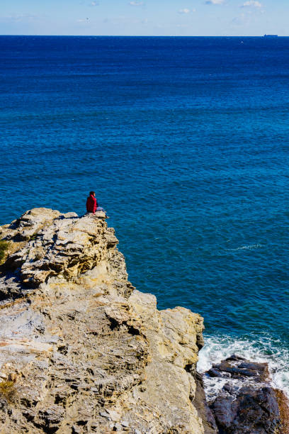 Tourist woman on spanish rocky coastline in Murcia region. Mediterranean Sea coast landscape, Calblanque Regional Park.