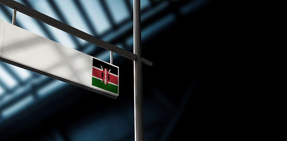Flag of Kenya on airport departure information board. Close-up. Roof construction in the background. Blue color. Horizontal orientation. Ne people. Copy space.