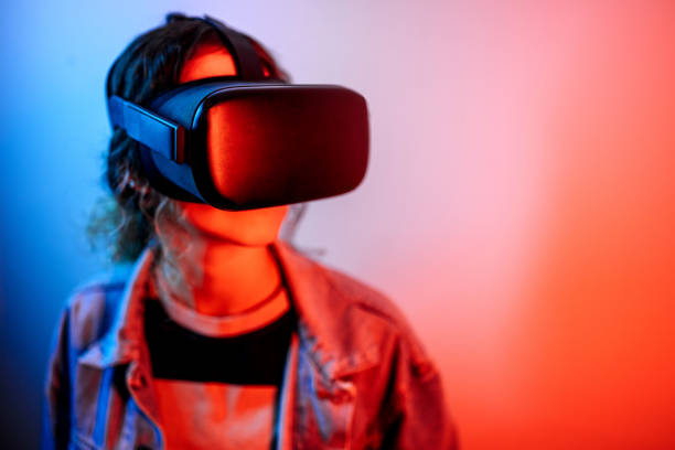 istock Young hipster woman wearing virtual reality goggles in studio with neon lights 1452486141