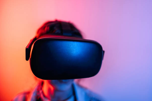 istock Young black woman playing game using VR glasses, enjoying 360 degree virtual reality headset for gaming, isolated on background with neon lights 1452487090