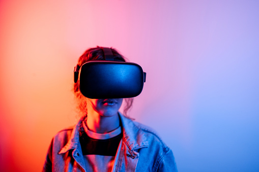 Neon portrait of young woman wearing virtual reality headset
