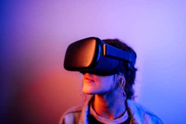 istock Young hipster woman wearing virtual reality goggles in studio with neon lights 1452487122