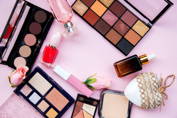 istock Make up set eyeshadows, powder, lipstick, perfume, nail polish on pink background 1452487321