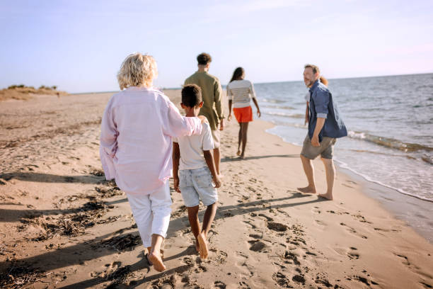 istock Three generation white family walking together on a sunny beach 1452488165