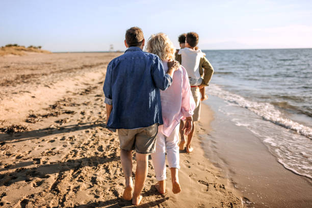 istock Three generation white family walking together on a sunny beach 1452488288