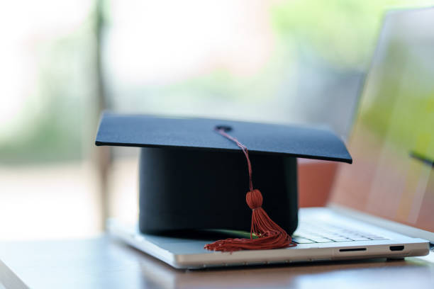 istock Graduation cap with laptop pace on wood table background. 1452491316