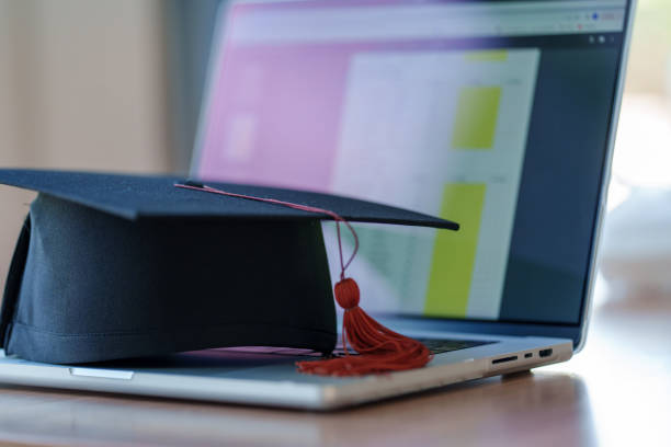 istock Graduation cap with laptop pace on wood table background. 1452491319