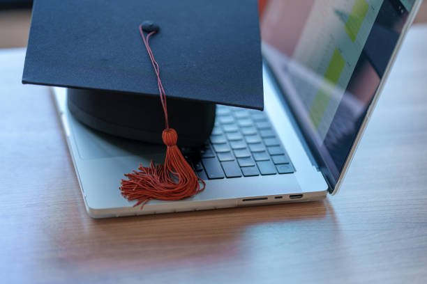 istock Graduation cap with laptop pace on wood table background. 1452491327
