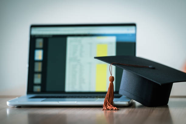 istock Graduation cap with laptop pace on wood table background. 1452491328