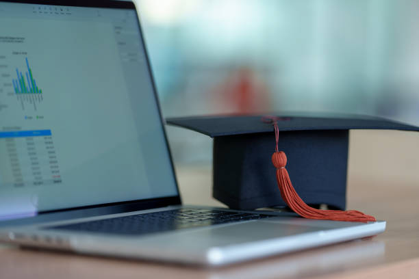 istock Graduation cap with laptop pace on wood table background. 1452491338