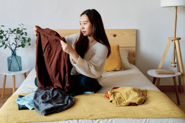 istock Smiling Asian woman sitting on bed 1452492177
