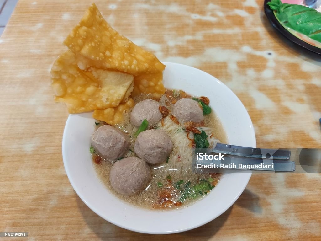 Meatball on a white bowl. It is authentic food from indonesia. Meatball on a white bowl. It is authentic food from indonesia. Concist of  noodle, fried dumplings and meatballs. Isolated background Asia Stock Photo