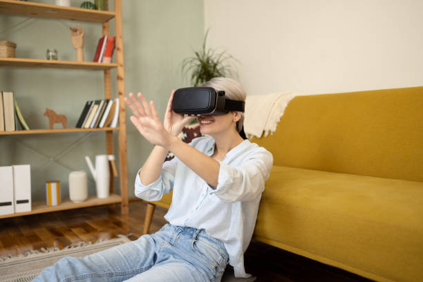 istock Young woman having fun playing games with VR glasses 1452499180