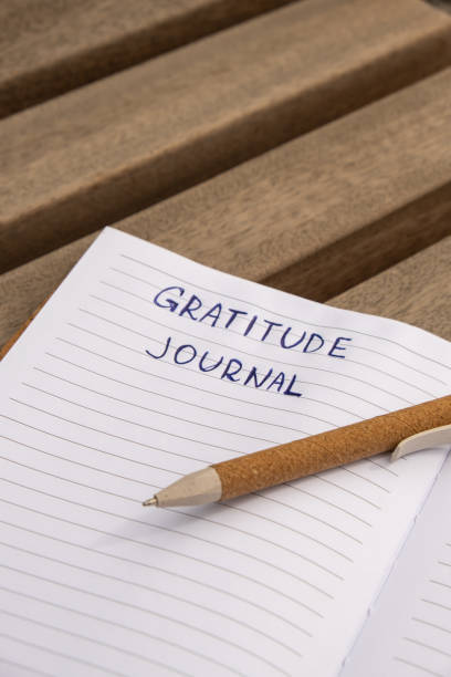 Writing Gratitude Journal on wooden bench. Today I am grateful for. Self discovery journal, self reflection creative writing, self growth personal development concept. Wellbeing spiritual health, being mindful, holistic health practices