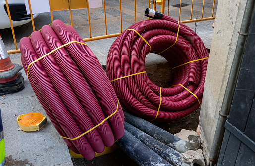 Rolled up plastic water pipes ready for installation in the Catalonian city of Girona. An old cobbled street is being dug up so that old water pipes can be replaced with new pipes, before the old cobble stones are replaced and levelled.