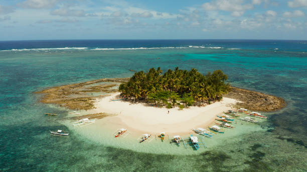 Tropical Guyam Island with a sandy beach and tourists.